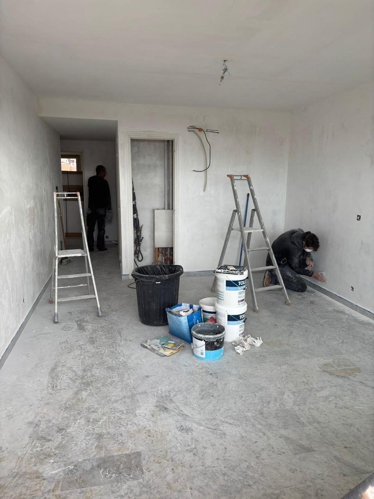 Équipe d'artisans Dol Multiservices en pleine préparation des murs et finitions lors de la rénovation d'un salon au Cannet.